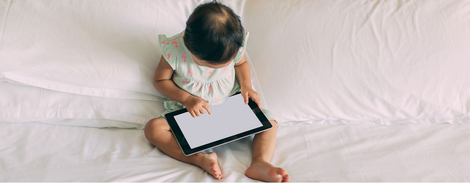 Enfant assis devant un écran de tablette