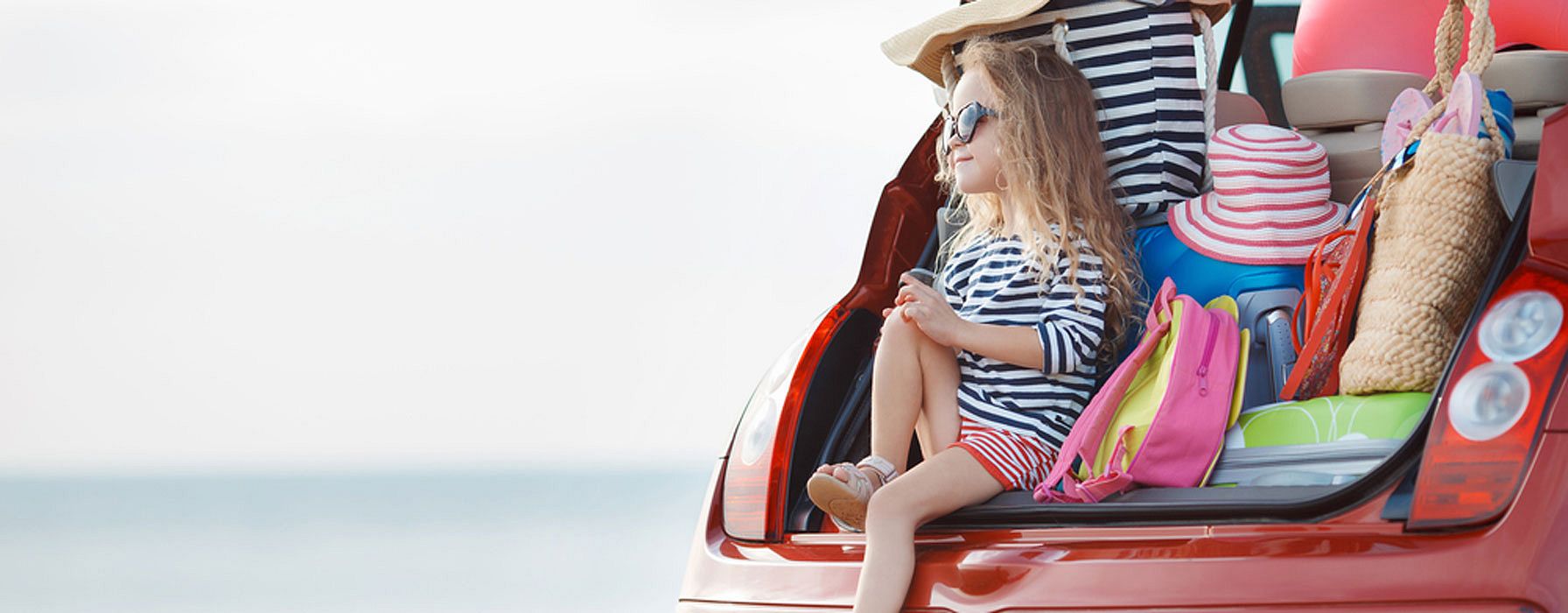 Enfant près d'une voiture avec valise