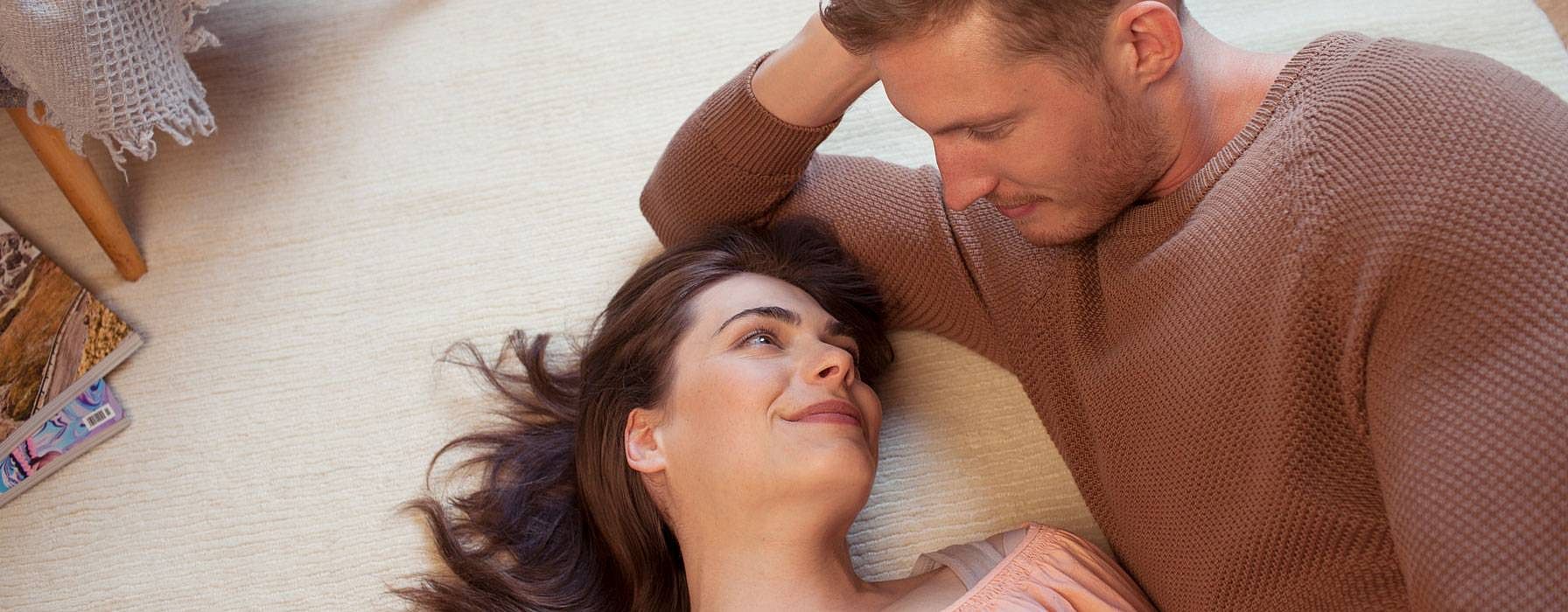 Paar liegt auf dem Boden und schaut sich an