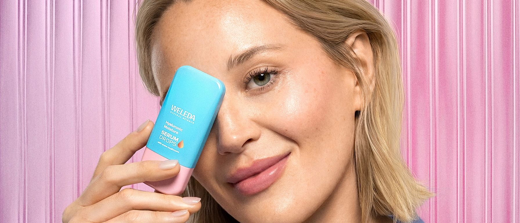 Frau hält Produkt vors Gesicht