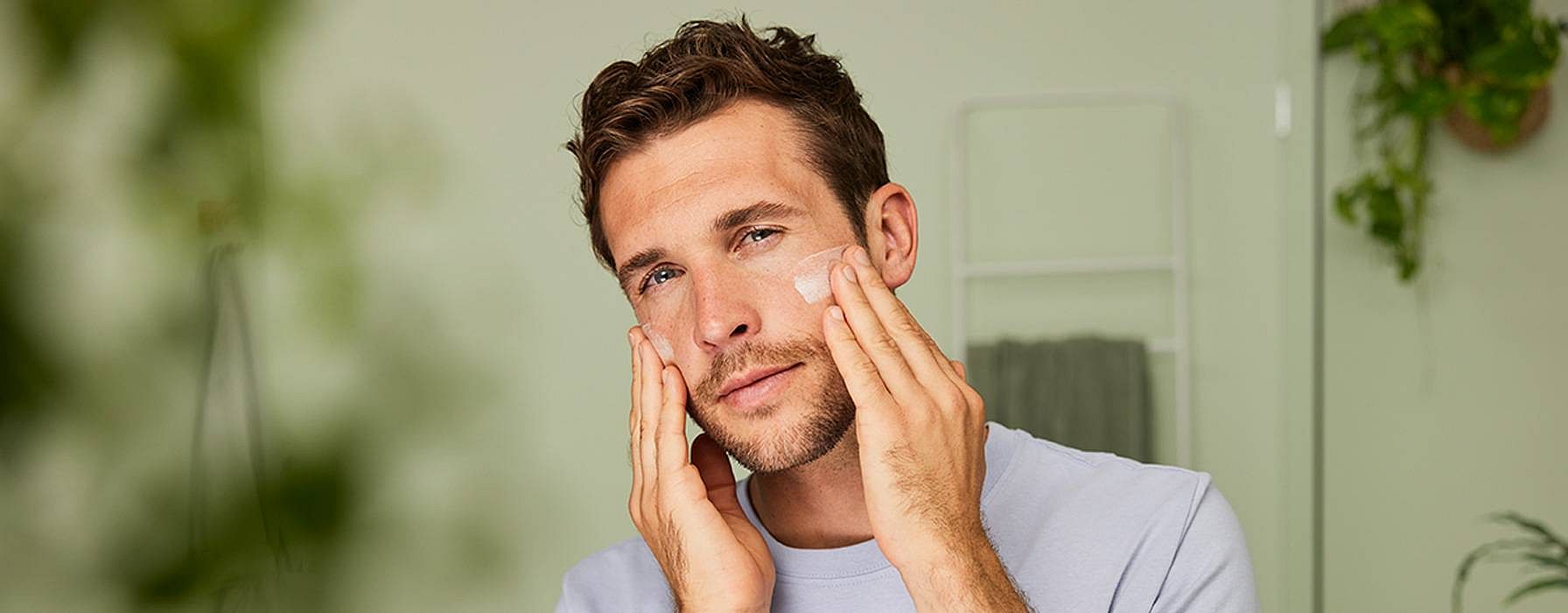 Un homme se met de la crème sur le visage
