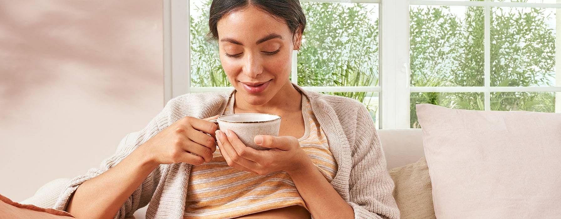 une femme enceinte boit du thé