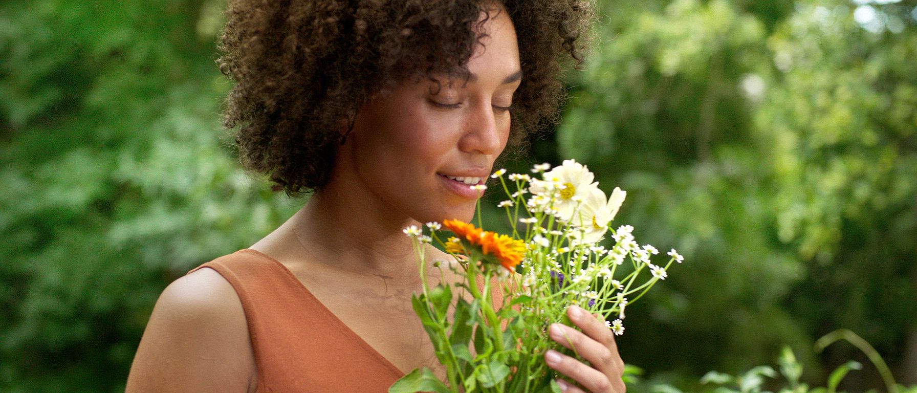 Femme dans la nature sentant les fleurs