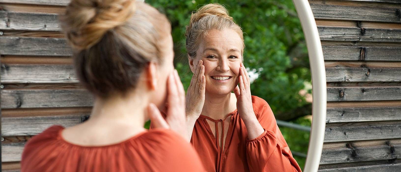 Femme souriante devant le miroir