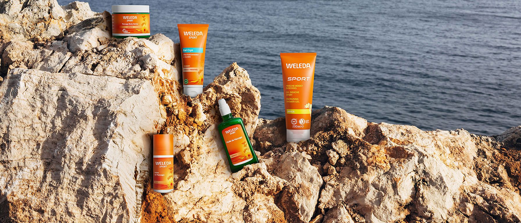 Produits à l'Arnica Weleda sur un rocher au bord de la mer
