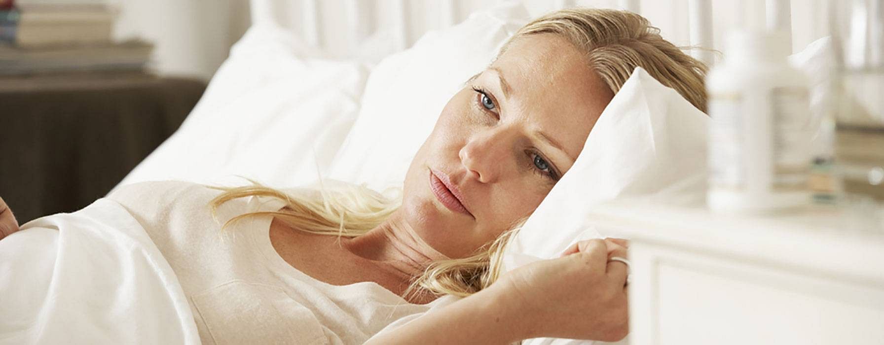 Schwangere Frau liegt im Bett