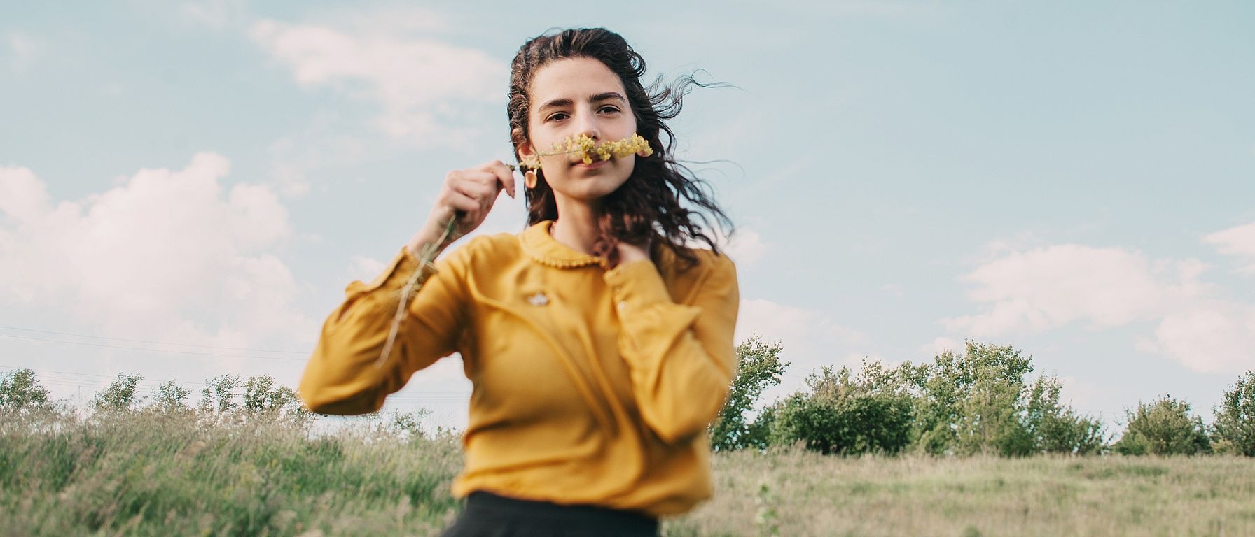 Jeune femme sentant une fleur