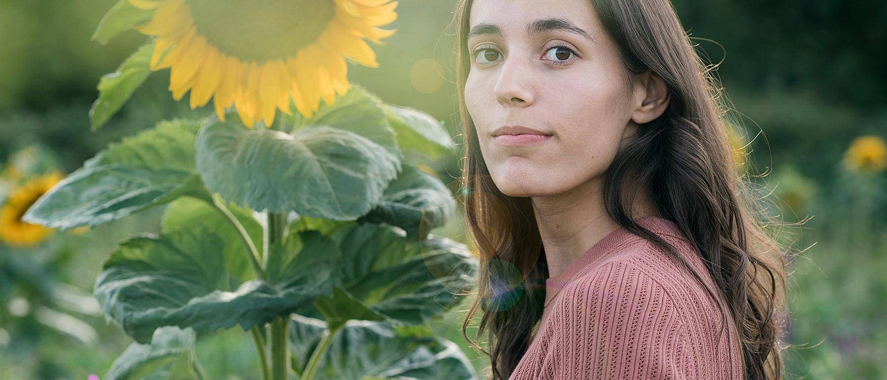 Frau in einem Sonnenblumenfeld an einem sonnigen Tag