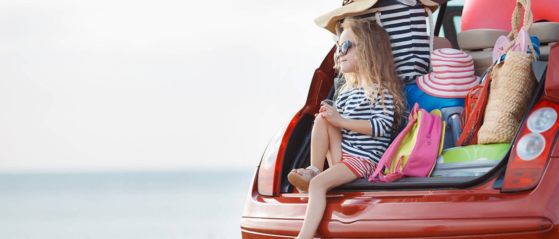 Enfant près du coffre rempli de valises