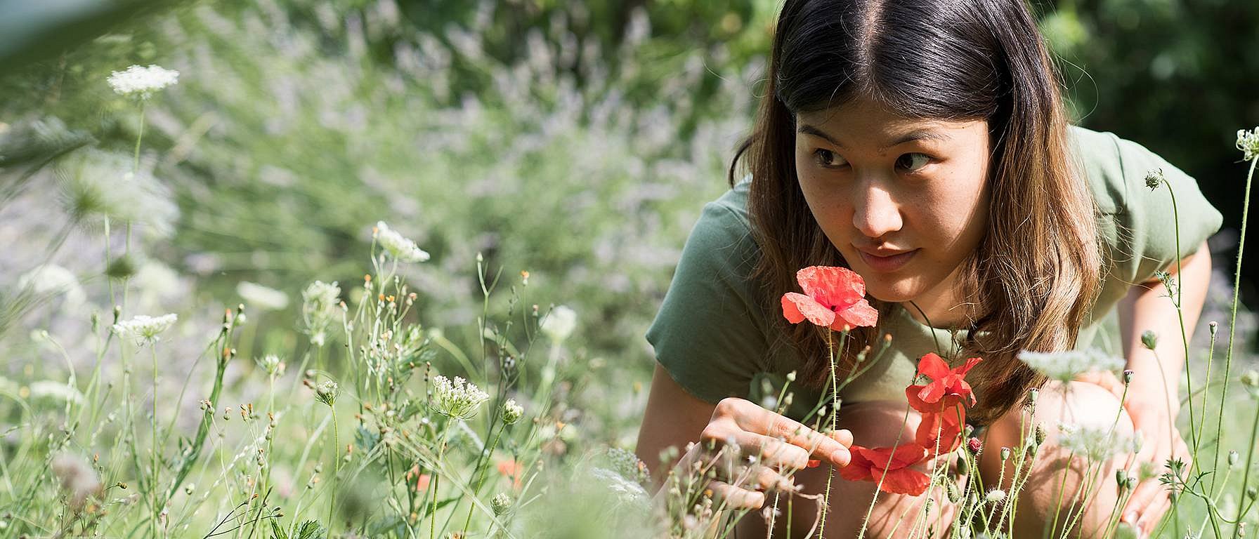 Une femme sent des fleurs