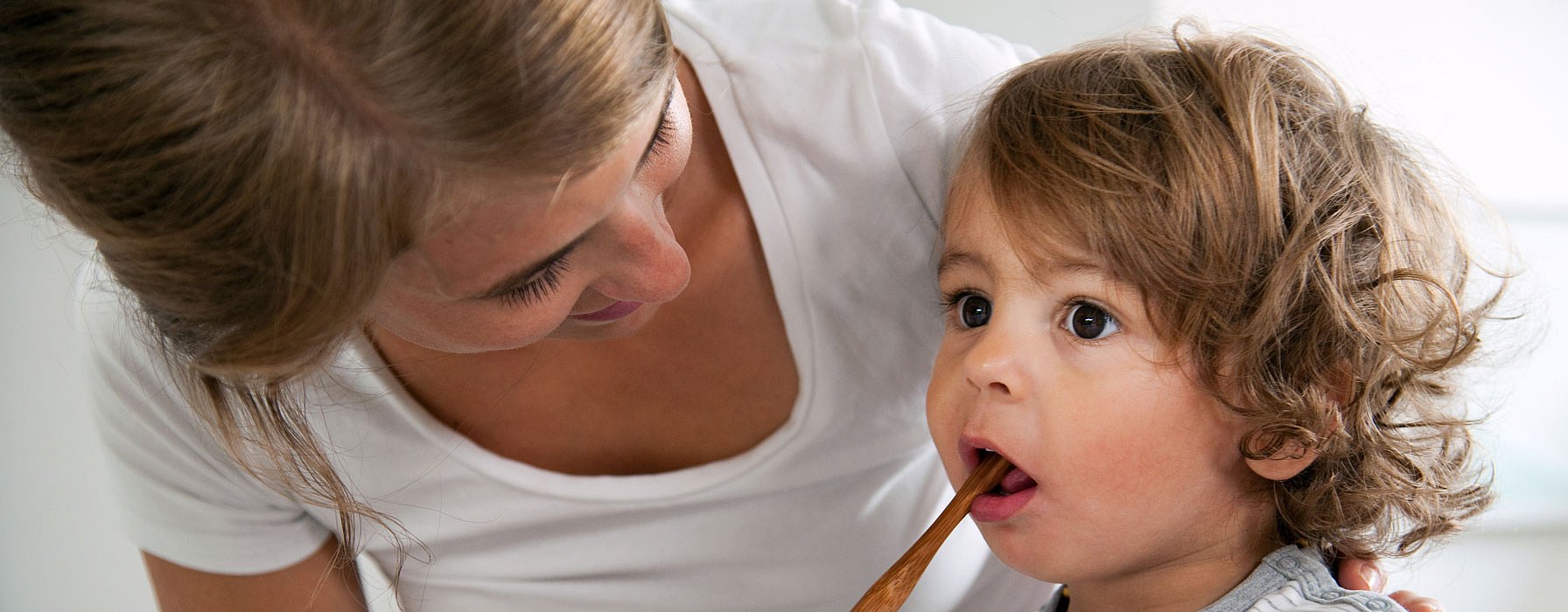 Une mère brosse les dents de son enfant