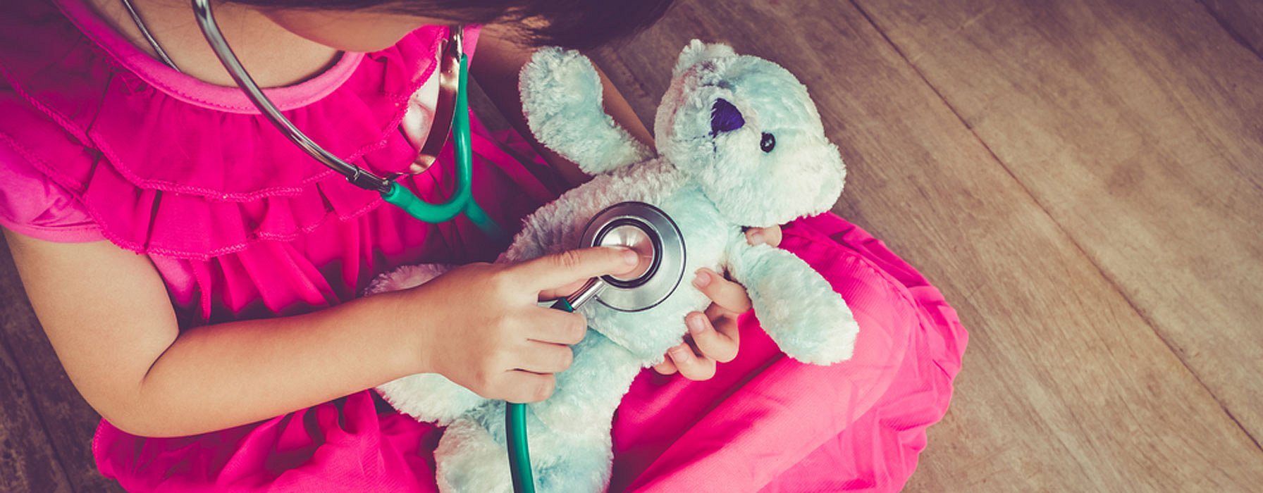 Enfant jouant avec un ours en peluche