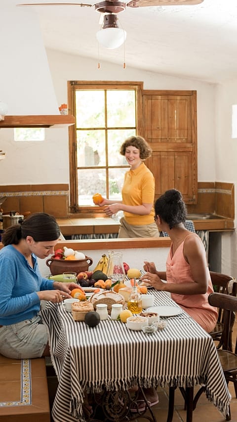 Trois femmes dans une cuisine en train de manger