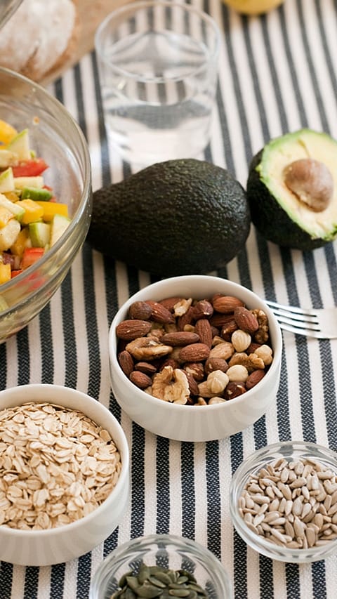 Aliments sains ; noix, graines, flocons d'avoine, avocat, salade de renard