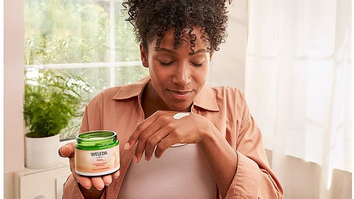 Frau mit Schwangerschafts Bodybutter in der Hand