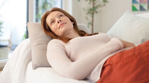 Frau liegt auf Sofa