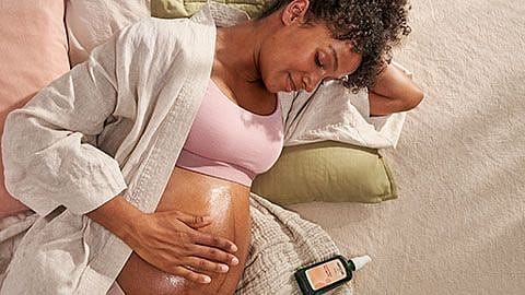 une femme enceinte se masse le ventre