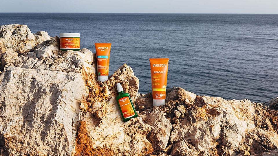 Weleda Arnika Produkte auf einem Felsen am Meer