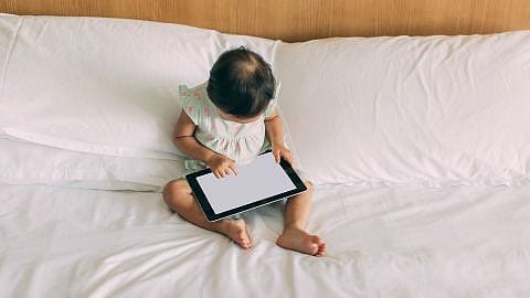 Enfant assis devant un écran de tablette