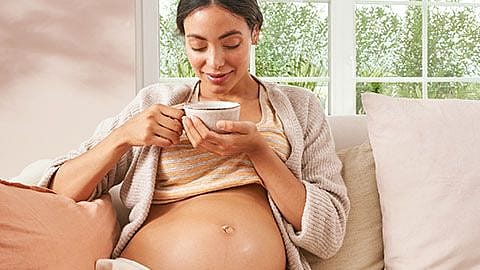 une femme enceinte boit du thé