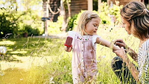 Frau tröstet Kind mit Insektenstich