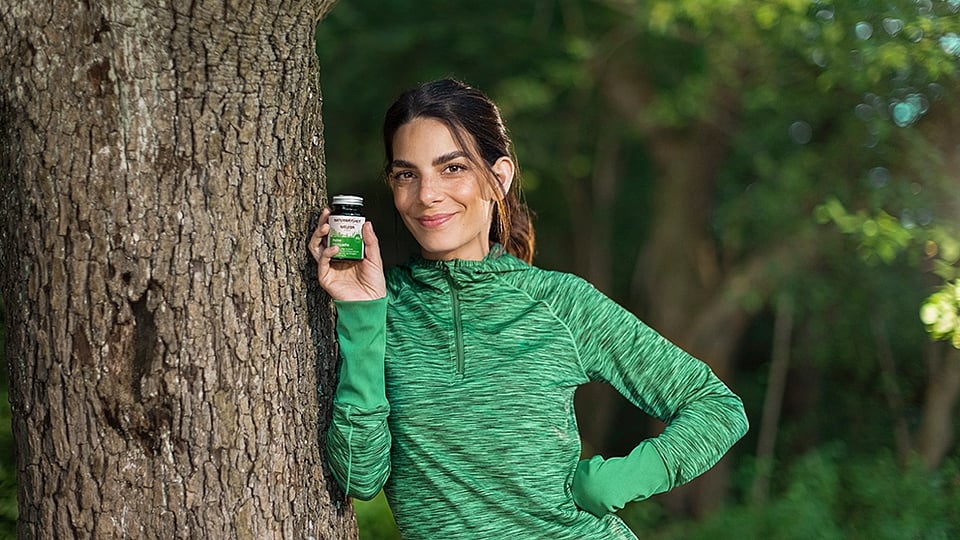 Sportliche Frau am Baum