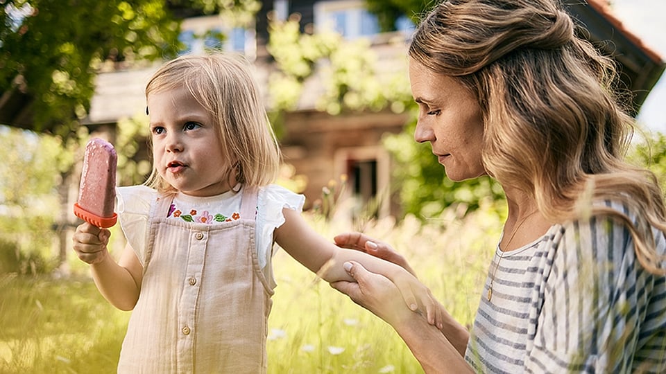 une femme traite une piqûre d'insecte de son enfant