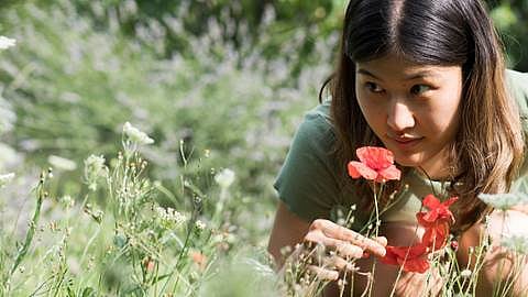 Une femme sent des fleurs