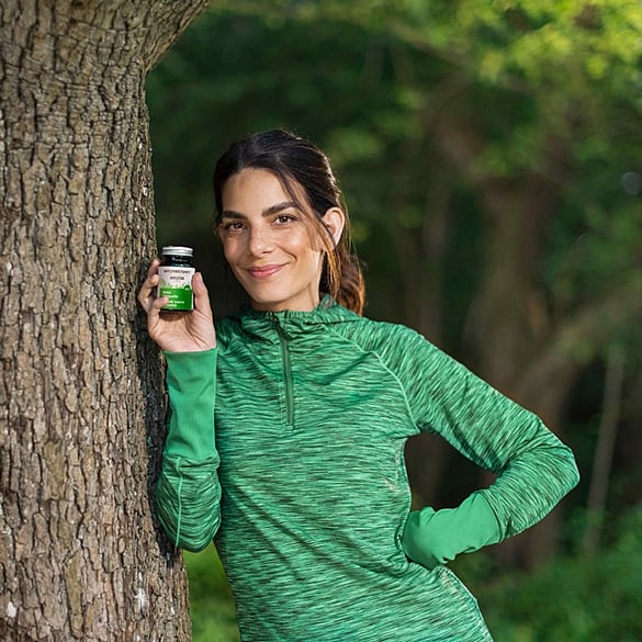 Sportliche Frau am Baum