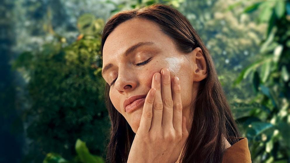 Une femme se met de la crème sur le visage