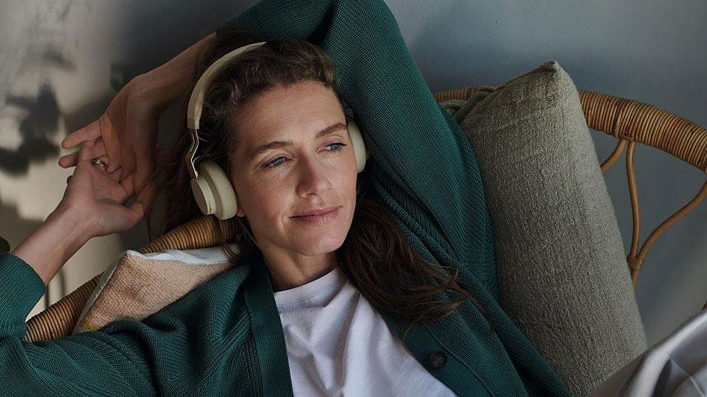 Femme allongée, détendue, écoutant de la musique avec des écouteurs