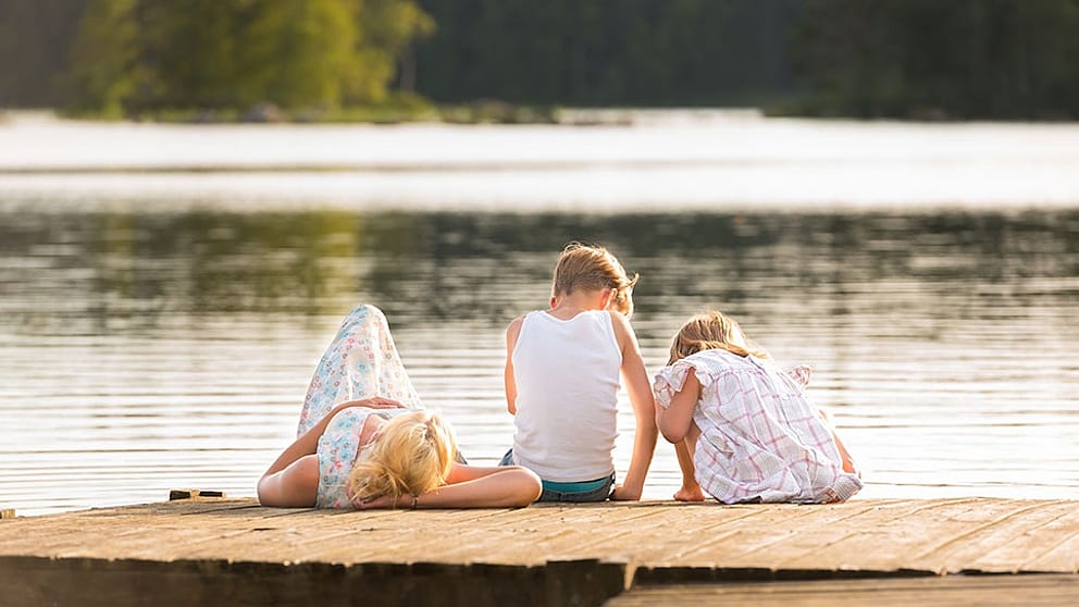 Mère détendue avec ses deux enfants au bord du lac