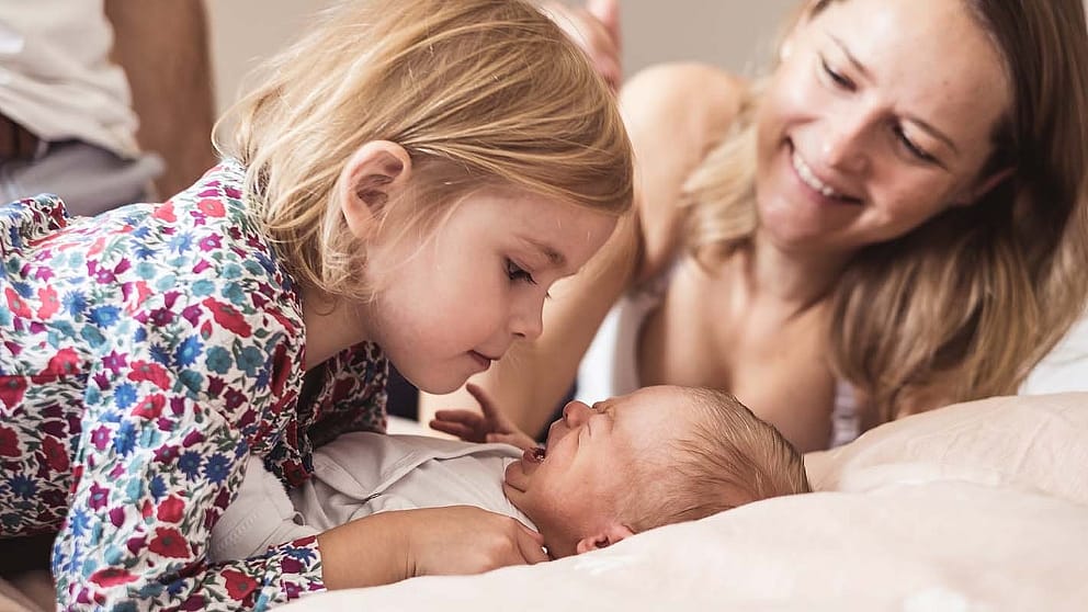 newborn with sister and mum