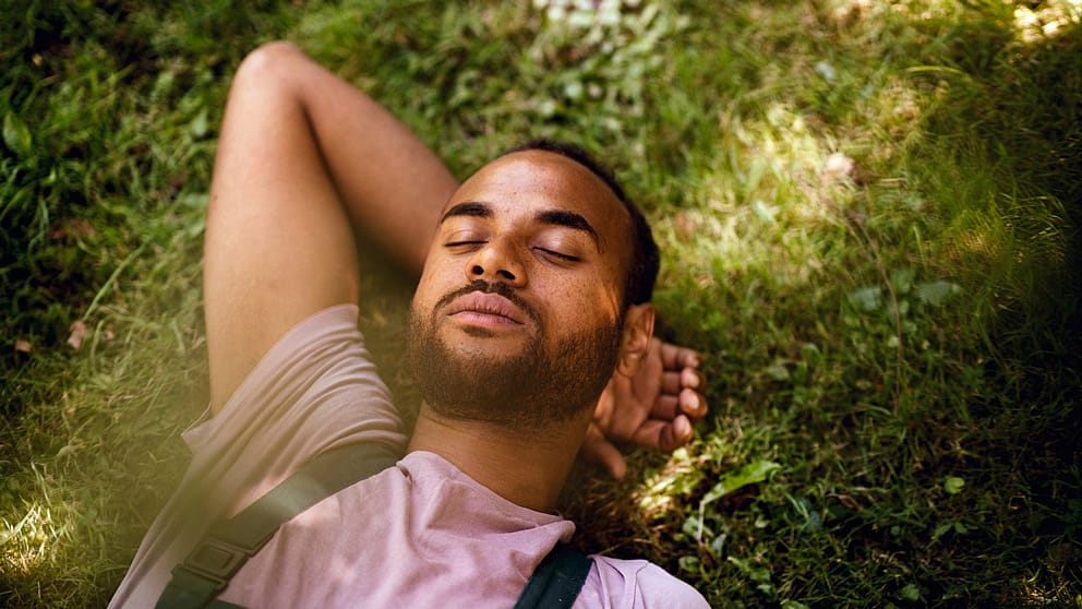 Homme dans la prairie, les yeux fermés