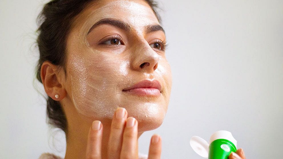 Femme applique Weleda Skin Food au visage