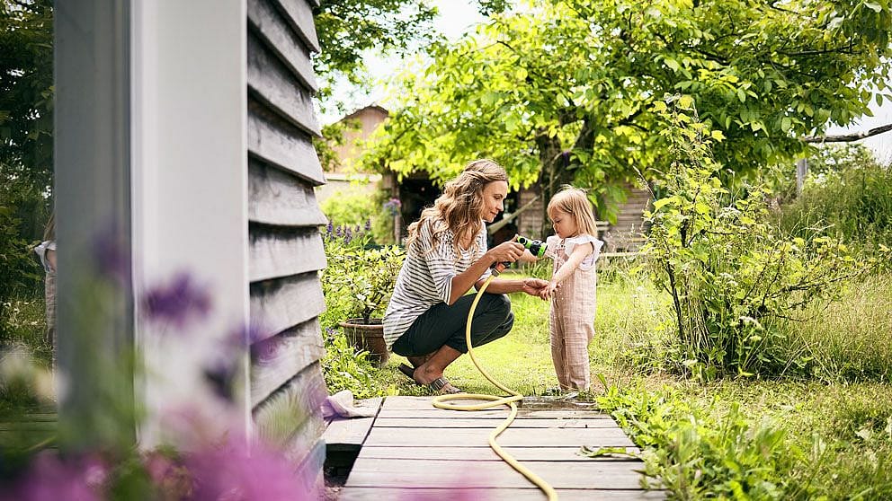 Mutter lindert Insektenstich mit Wasser beim Kind