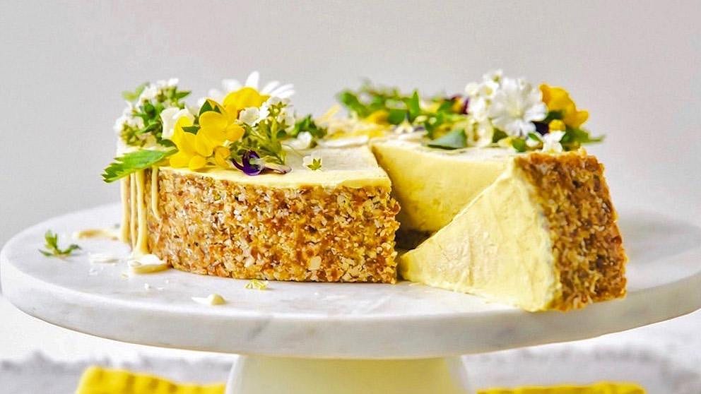 Zitronenkuchen mit Blüten und Zitronen auf einer Platte