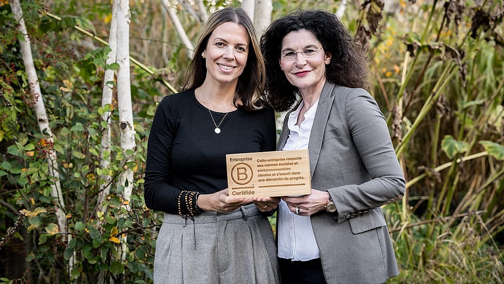 Nadine Santiago uhnd Tina Müller halten das hölzerne B Corp Logo in den Händen