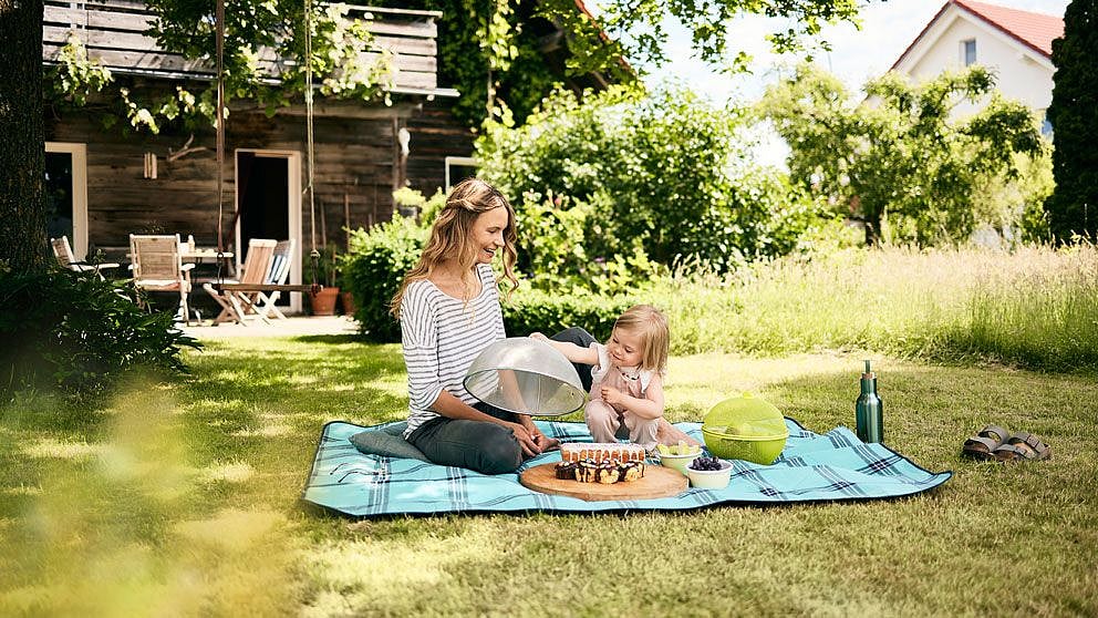 femme avec enfant au pique-nique et nourriture couverte