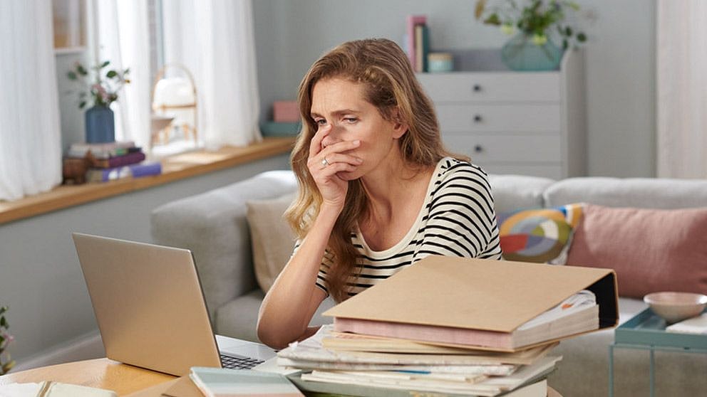 femme devant un ordinateur portable et de nombreux documents