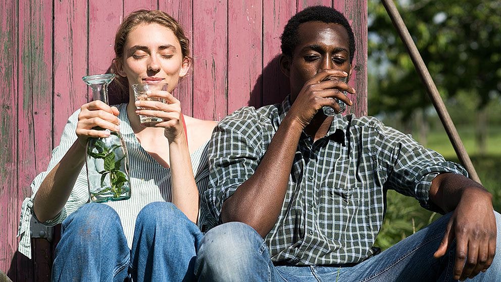 Frau und Mann ruhen sich draussen aus und trinken Wasser